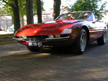 An ultra-rare Ferrari Daytona Spider roars up the tree-lined avenue after picking up an award