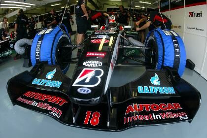 Justin Wilson's Minardi PS04 sits in the pit garage