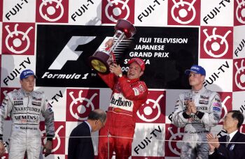 Rubens Barrichello lifts the winners trophy on the Suzuka podium flanked by Kimi Raikkonen and David Coulthard